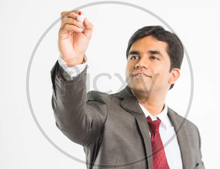 Indian young businessman writing with marker pen on blank/empty space