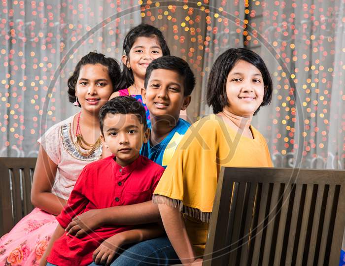 Portrait of Indian kids sitting on Sofa/Couch on diwali Festival night