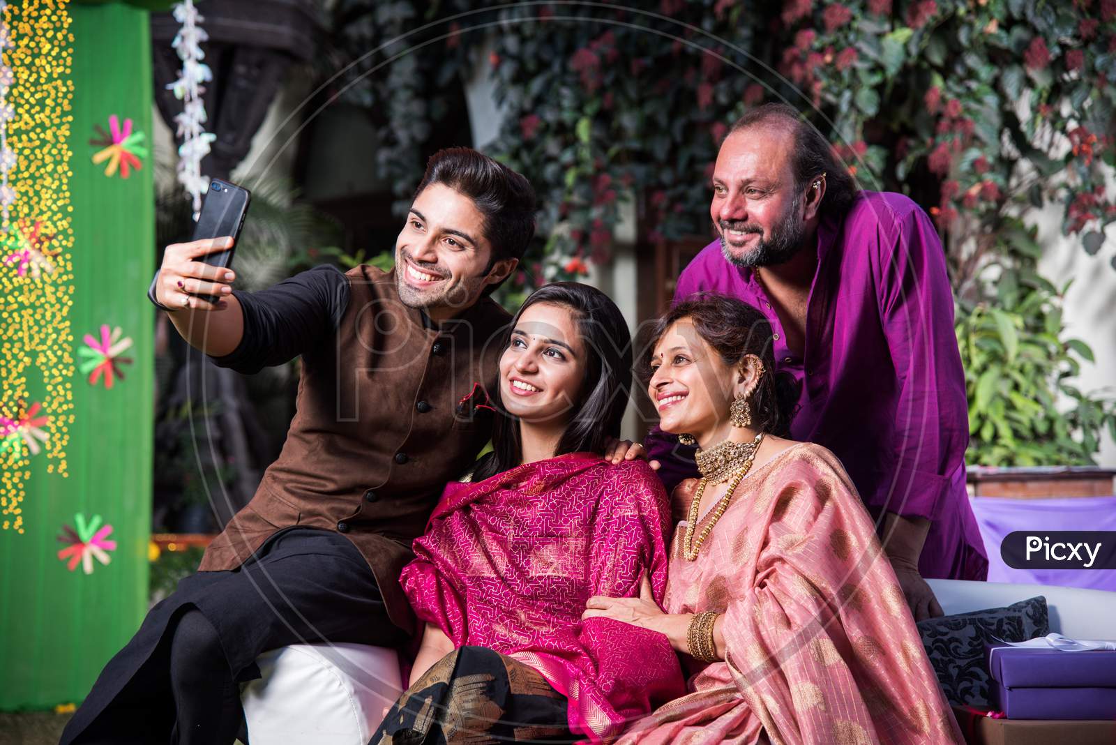 Indian family taking selfie picture using smartphone