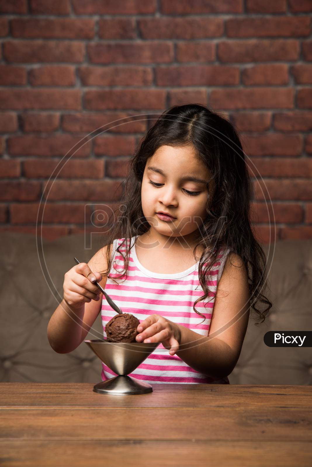 Indian Small girl eating Ice Cream in a bowl