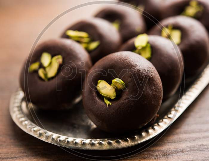 Chocolate Milk peda or pera or pedha made using sweet condensed Milk and cocoa powder, garnished with Pistachio. selective focus