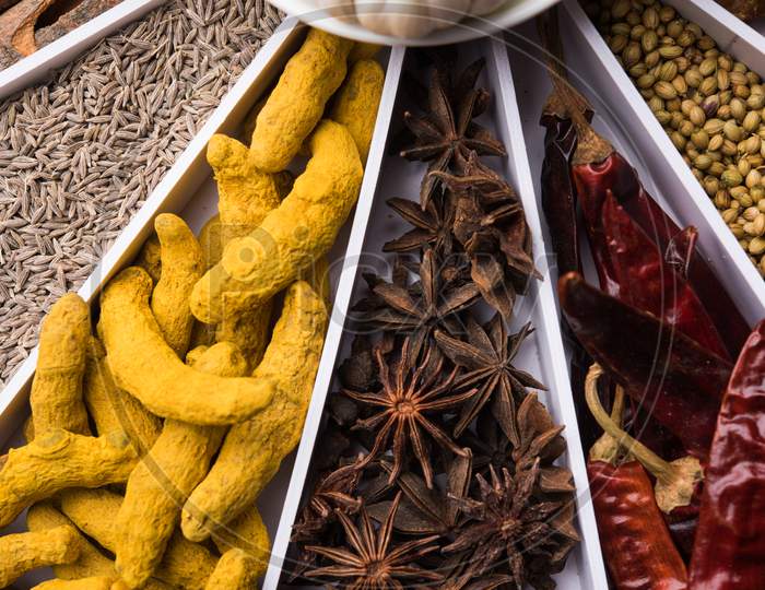 Indian Spices in white wooden box with cells, selective focus.