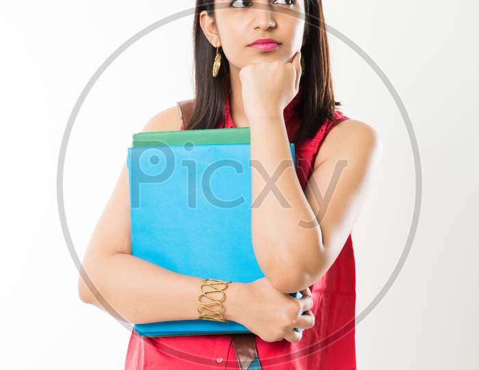 Pretty Indian/Asian College Girl holding books and bag while standing isolated over white background