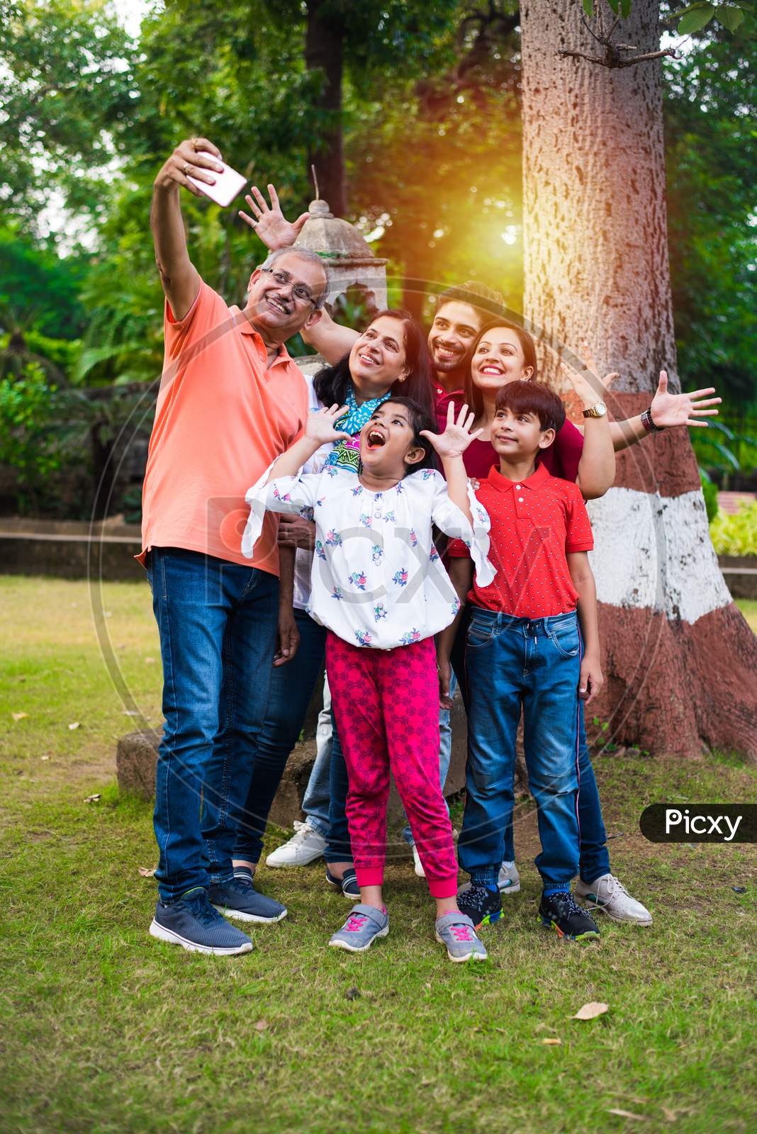 indian grandfather taking selfie picture of his family includes his wife, son, daughter in law and grand children