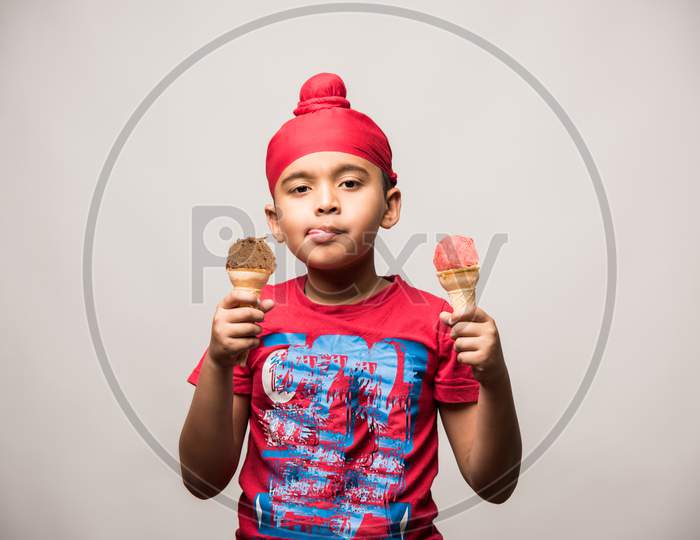 cute little Indian sikh/punjabi boy eating ice cream in cone