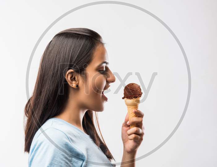 Beautiful young girl eating Ice cream in cone