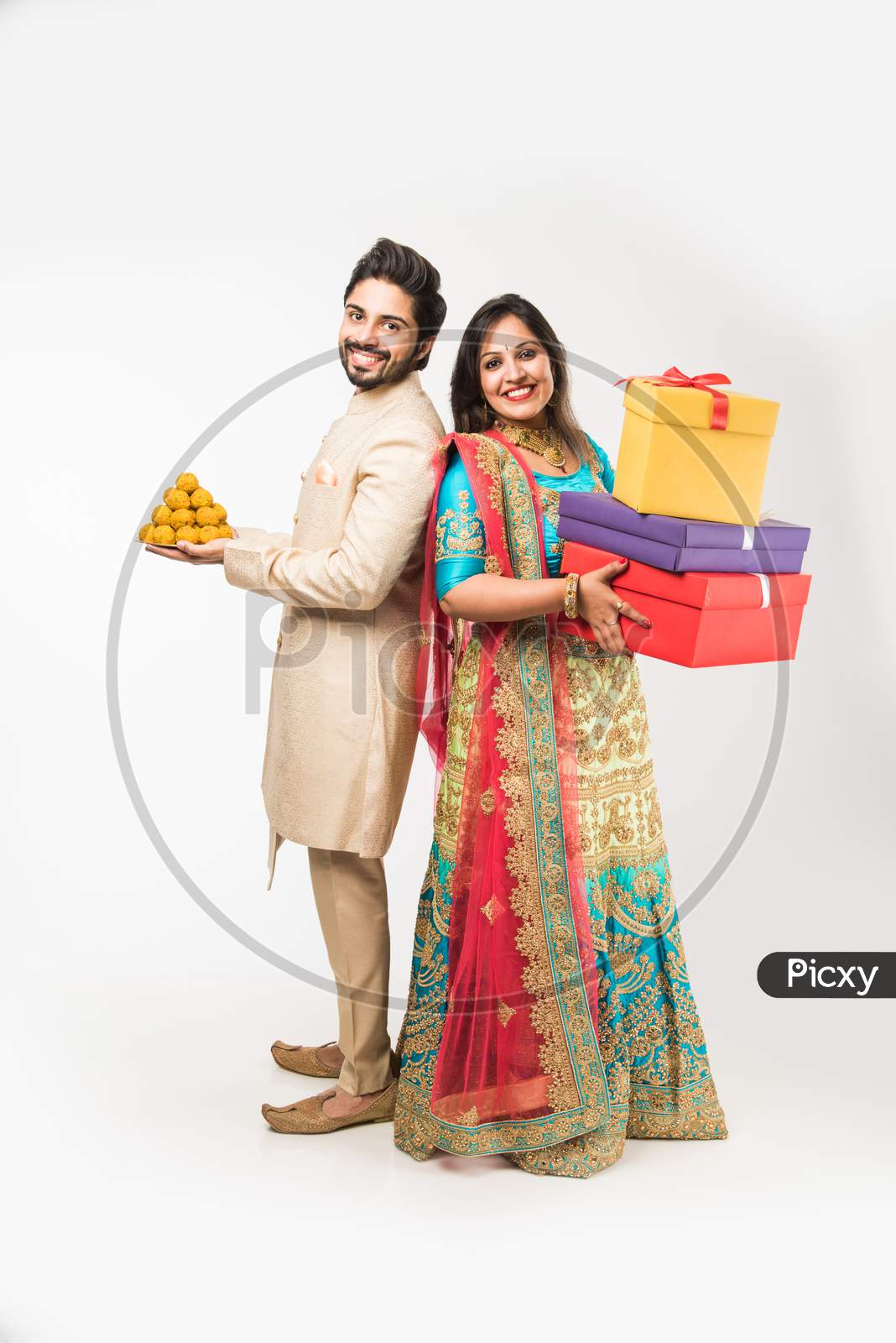 Indian couple with sweets and gift boxes