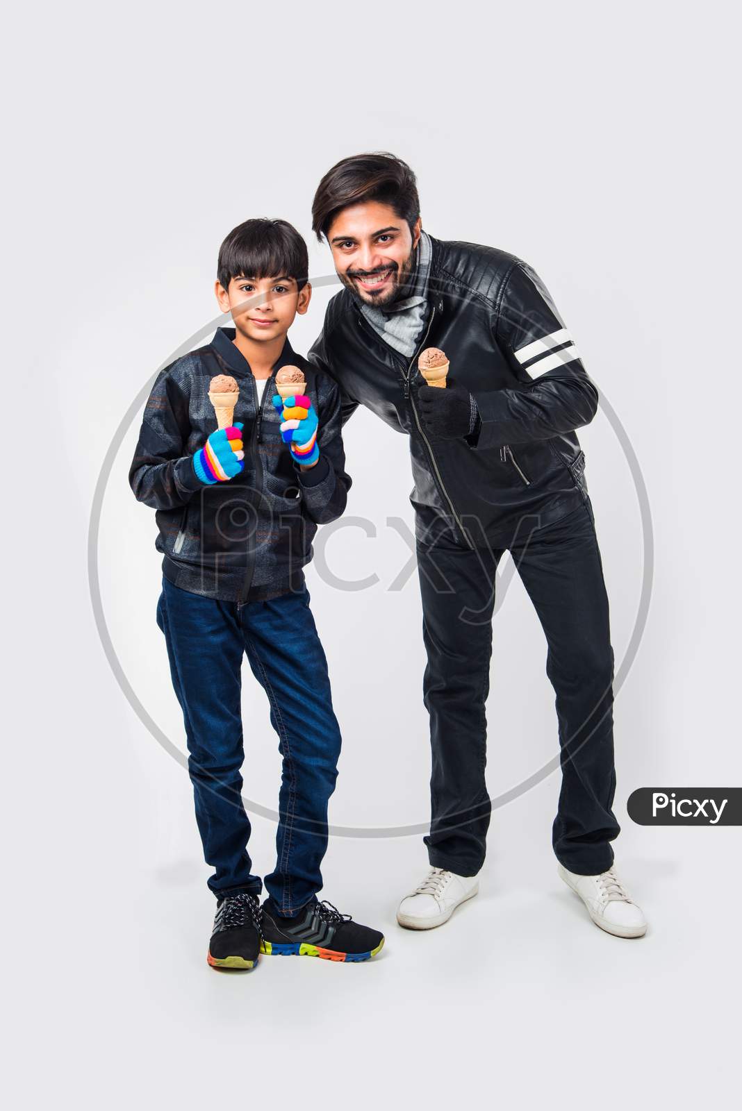 Indian Father and Son eating ice Cream in warm clothes on white background