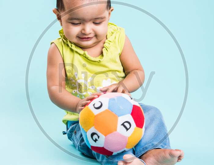 Small Indian Infant playing with colourful toys