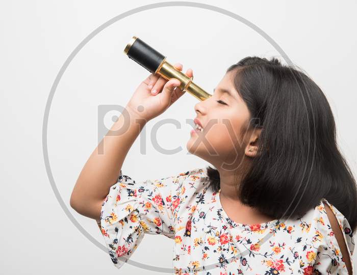 Cute little girl using stretch telescope and looking up in the sky