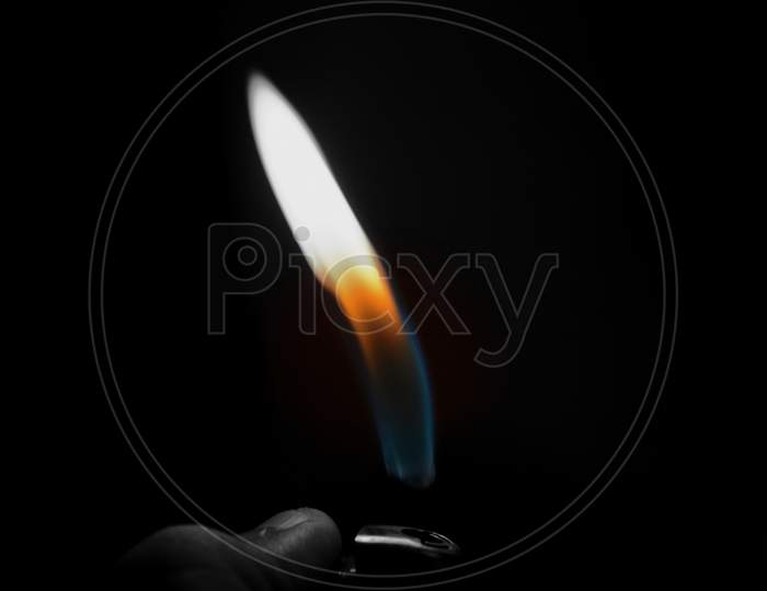 A Hand Lighting Up A Lighter On A Black Background