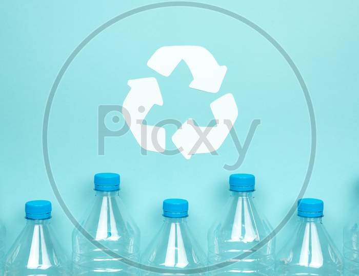 Clear Plastic Bottles With Caps On A Blue Background. Recycling And Environment Concept.