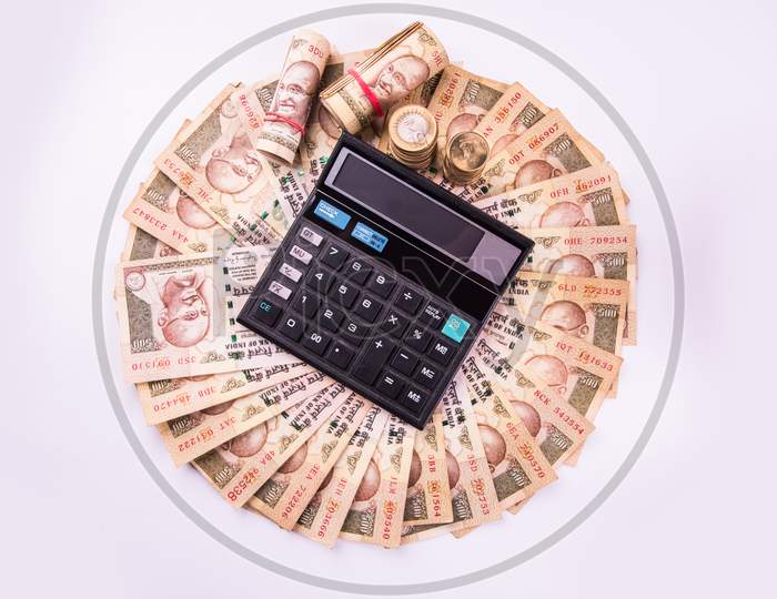 indian currency notes arranged in circular shape with calculator over it