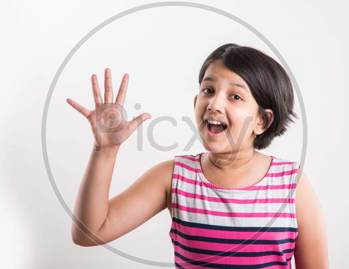 Indian small girl showing numbers with fingers over white background