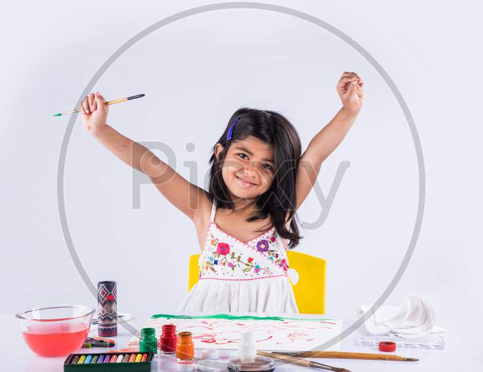 Little girl artist colouring with brush