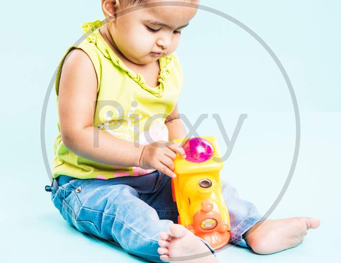 Small Indian Infant playing with colourful toys