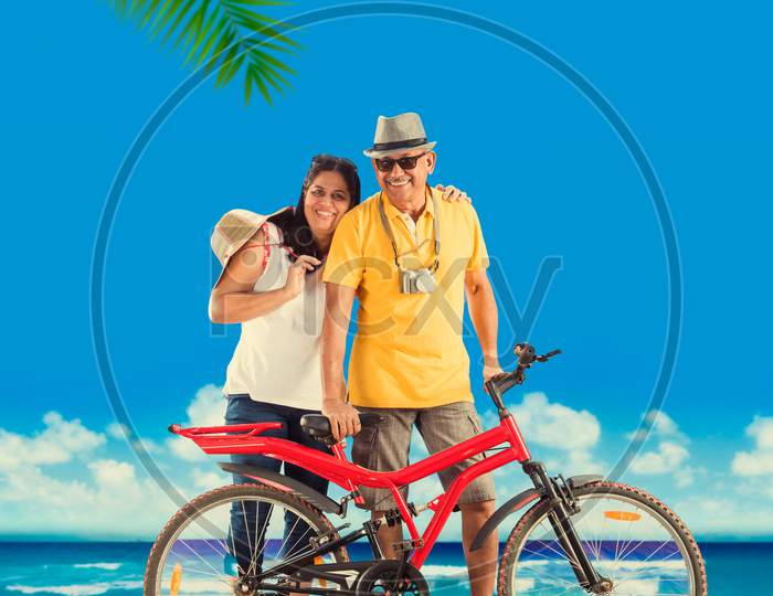 senior couple riding bicycle at beach
