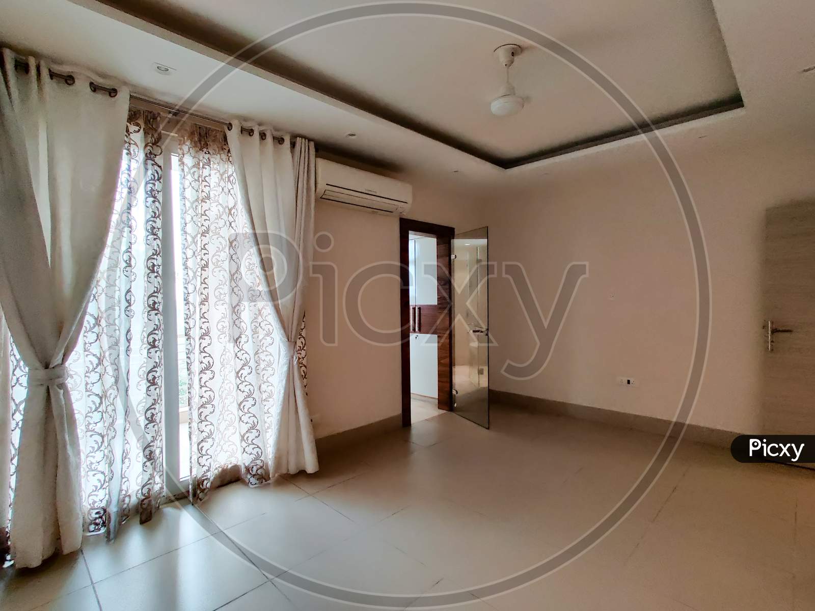Wide Angle Shot Of A Ready To Move In Apartment With Lace Curtains And Good Natural Light
