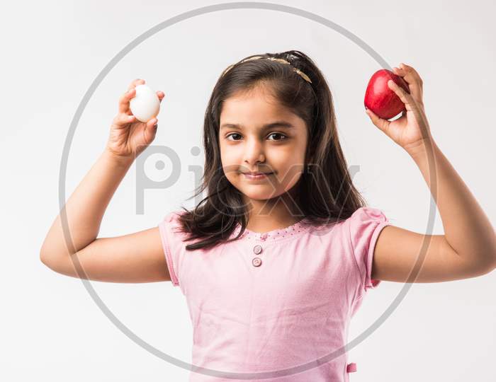 Small Girl eating egg and apple