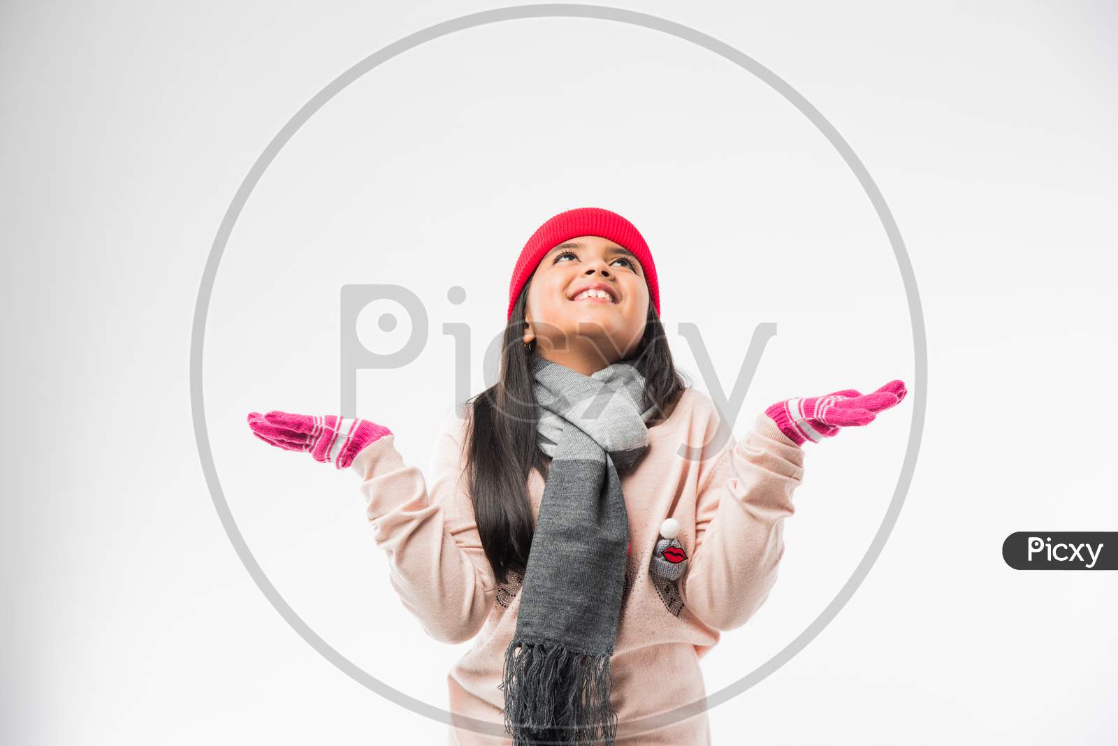 Indian cute little girl in winter wear, standing against white background