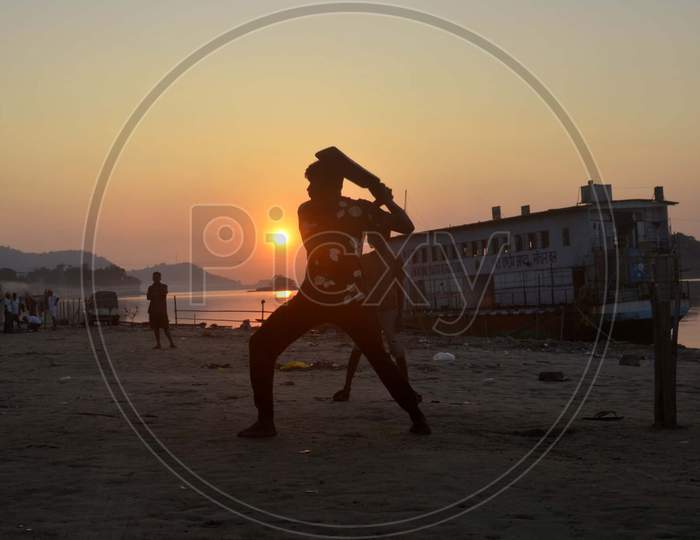 Boys playing cricket during Silhouette
