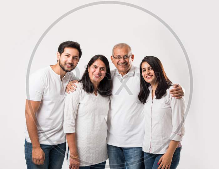 happy Indian family of 4 standing isolated over white background