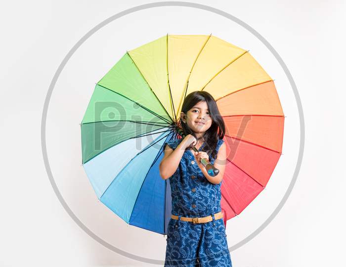 Indian Girl with big multicoloured umbrella, isolated over white