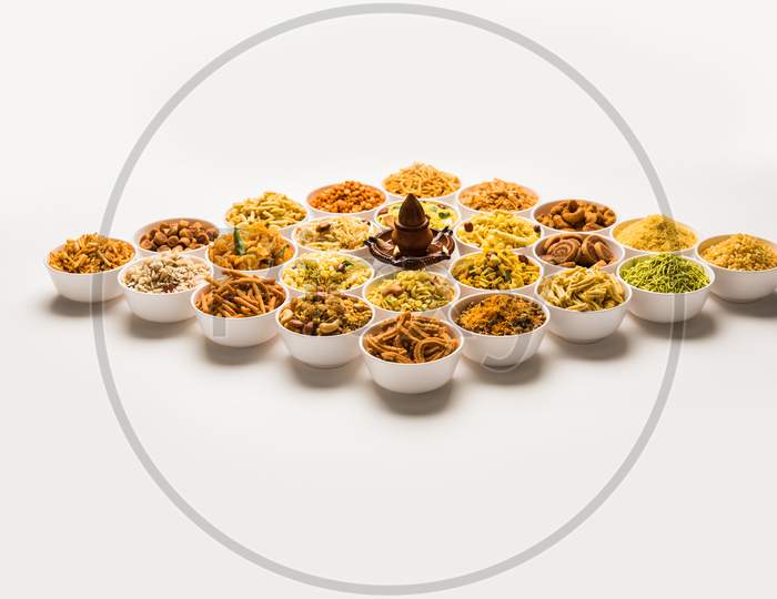 Rangoli of Farsan/snacks in bowls with diya