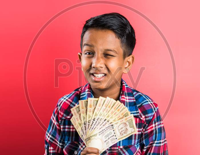 Kid/boy holding indian Currency note fan