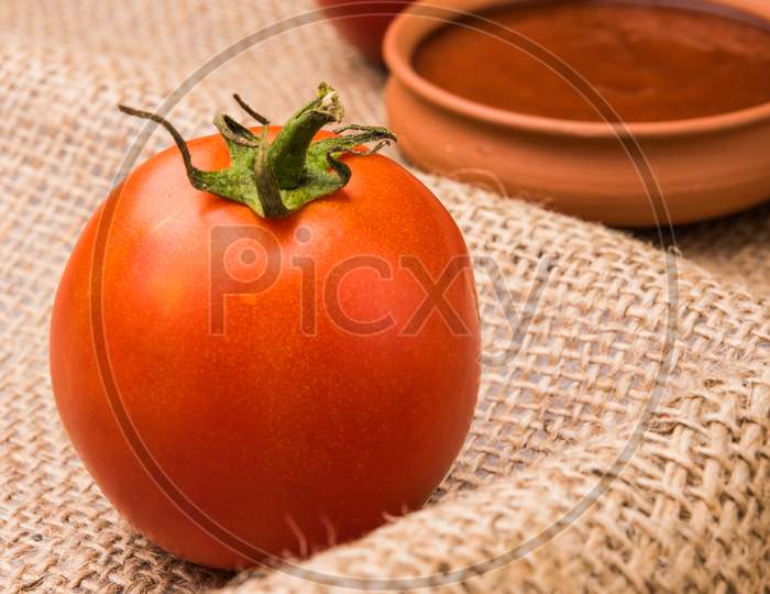 Farm Fresh Red Tomato with paste or puree in a ceramic bowl. Selective focus