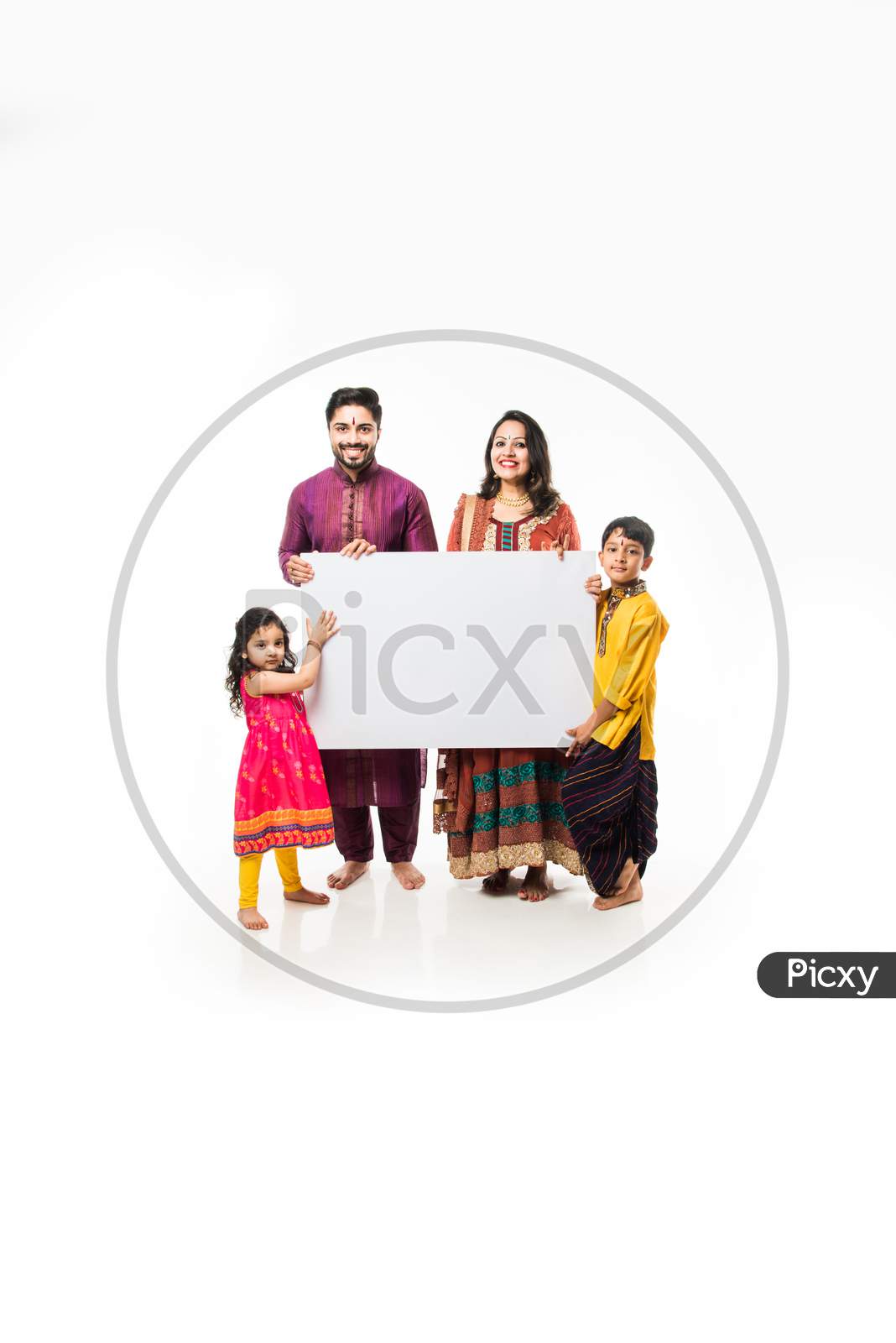Indian family celebrating Diwali while holding blank white board / placard. Standing isolated over white background and looking