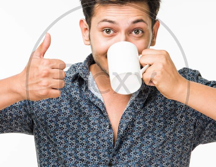Young man having hot tea/coffee in a mug