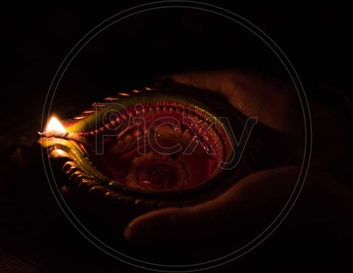 Hand holding diwali diya, closeup