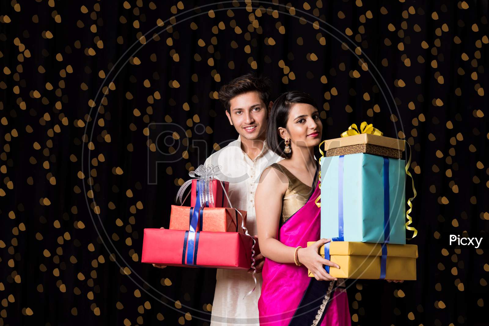 Indian young couple holding gift boxes