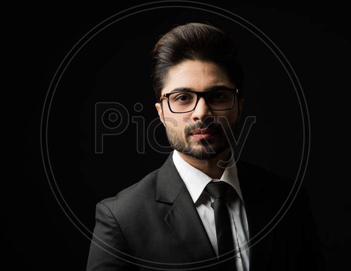 Portrait of Indian Male businessman standing against black background