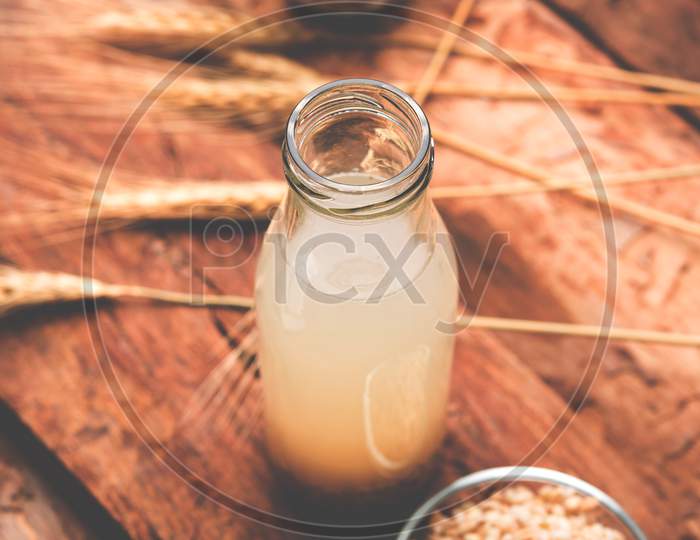 Barley water in glass with raw and cooked pearl barley wheat/seeds