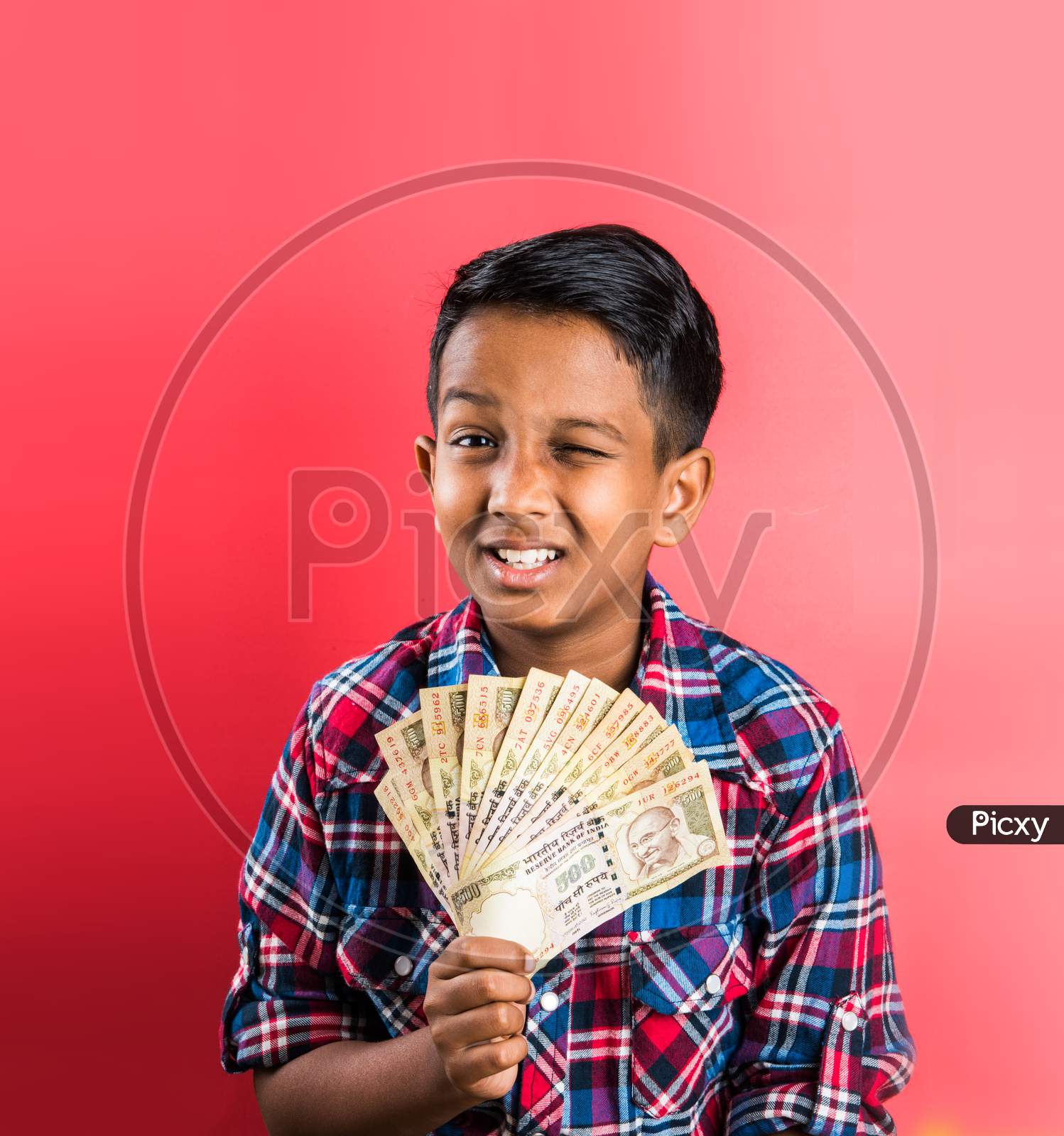 Kid/boy holding indian Currency note fan