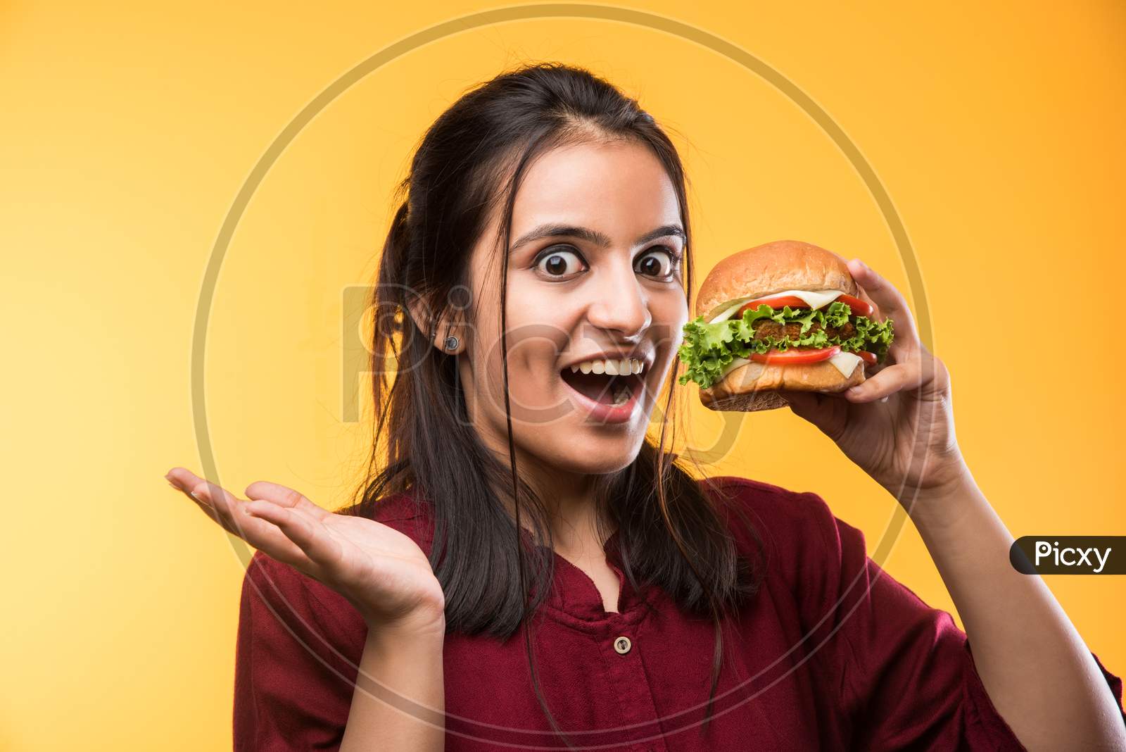 Image of Beautiful young girl eating burger-FJ262823-Picxy