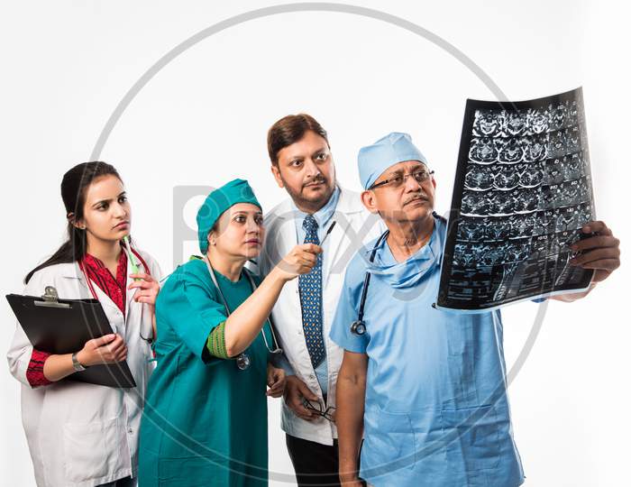 Indian/asian doctors looking an x-ray/MRI , isolated over white background. selective focus