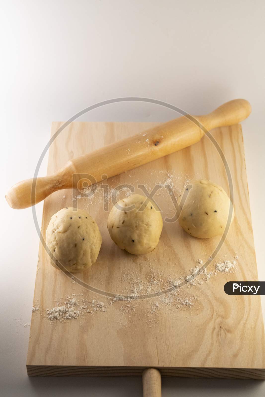 dough on rolling board with a rolling pin .