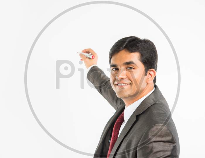 Indian young businessman writing with marker pen on blank/empty space