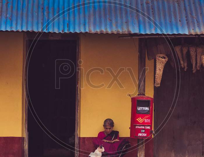 Woman sitting outside her house