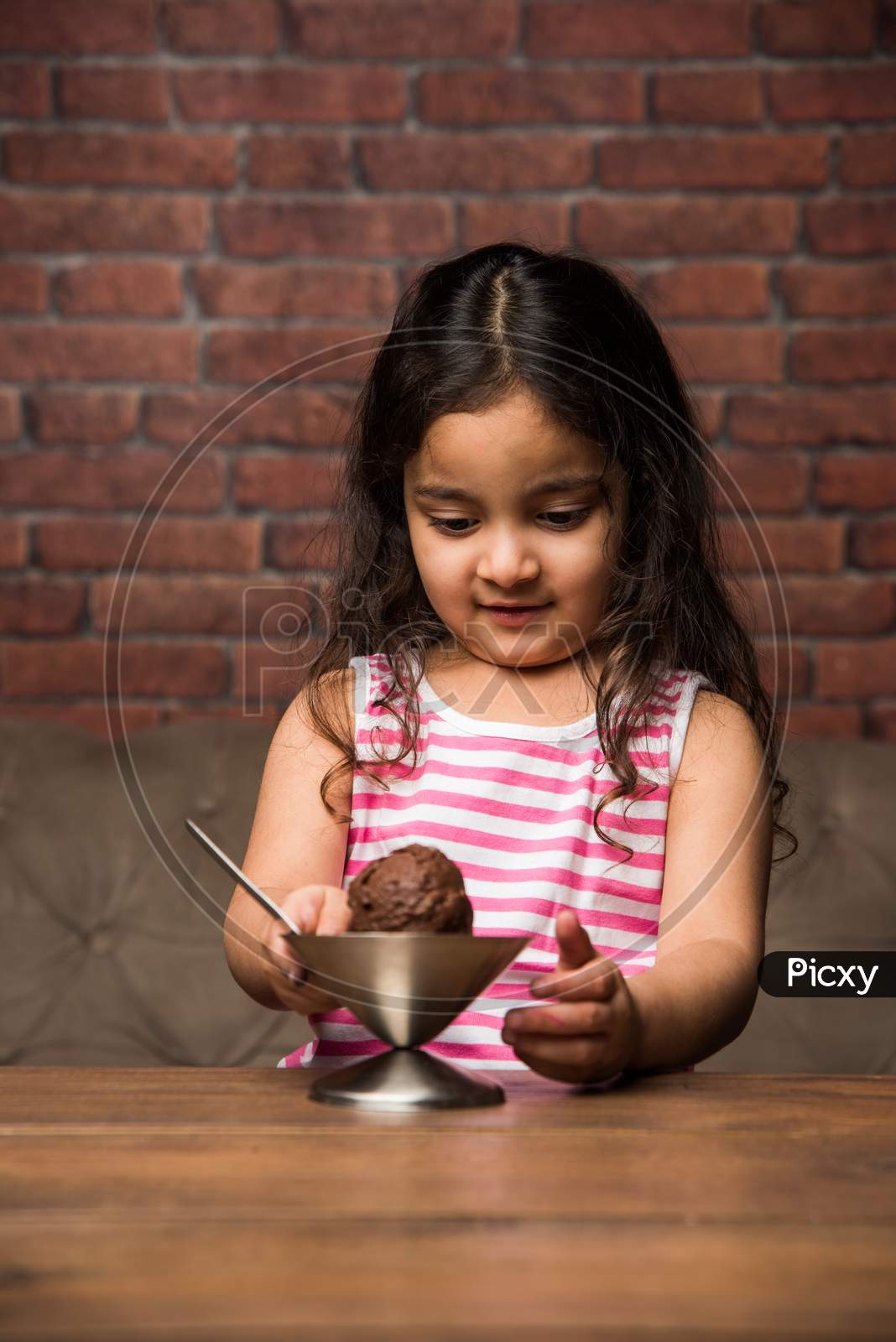 Indian Small girl eating Ice Cream in a bowl
