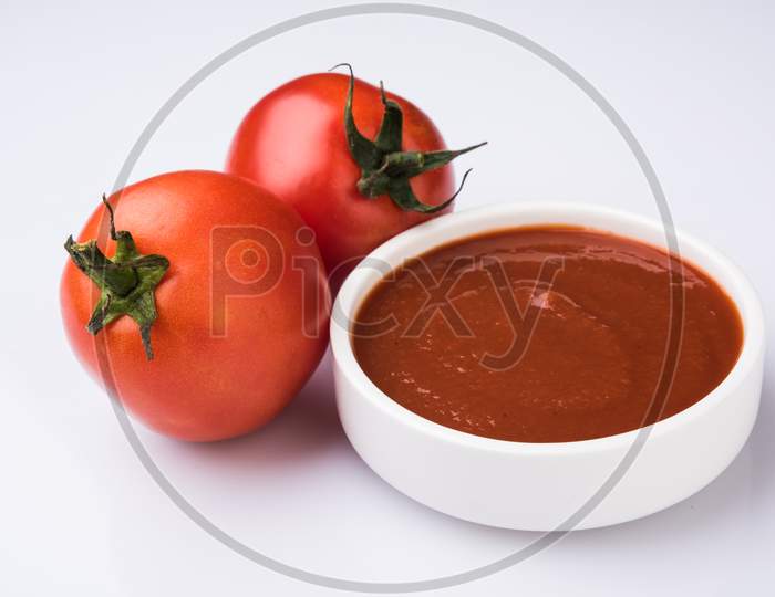 Farm Fresh Red Tomato with paste or puree in a ceramic bowl. Selective focus