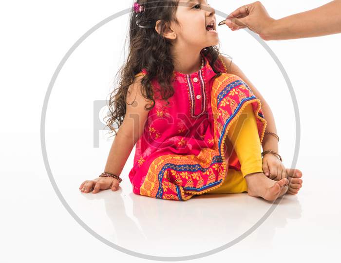 Portrait of cute little Indian girl model, standing isolated over white background