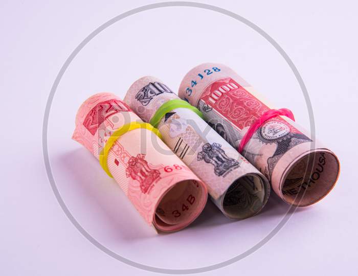 Roll of indian rupees with rubber band isolated on white background