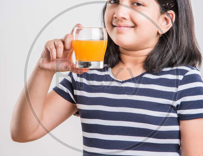 Cute little girl drinking mango juice or orange juice or cold drink