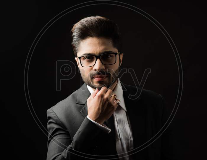 Portrait of Indian Male businessman standing against black background