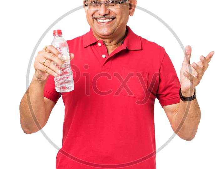 senior indian / asian man drinking fresh water while or after weight training or gym, keeping himself dehydrated