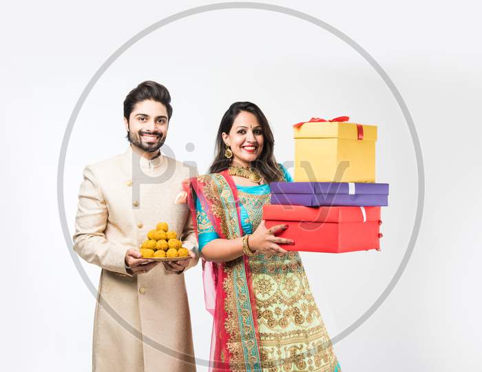 Indian couple with sweets and gift boxes